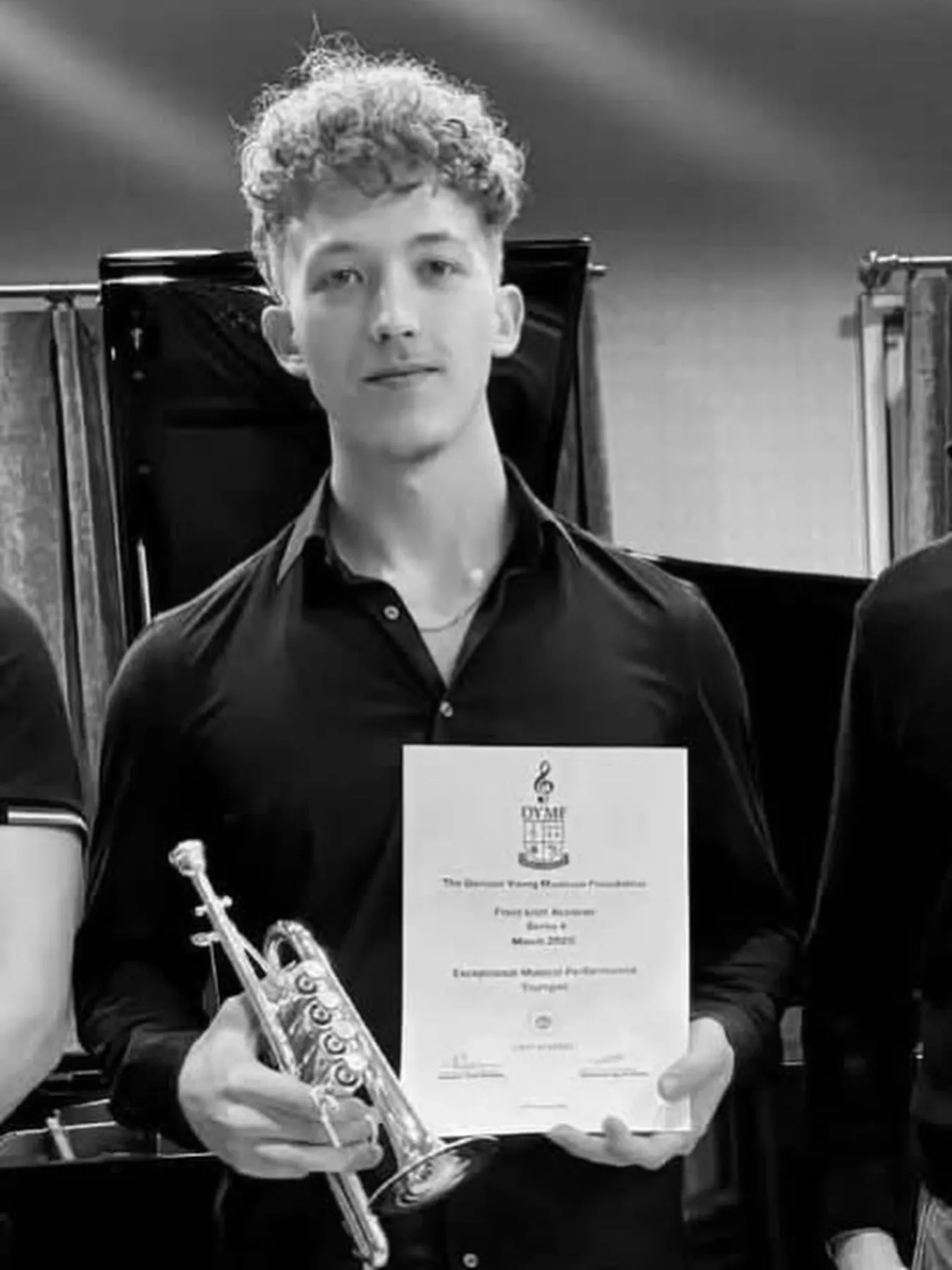 György Breznyán-Tokai holding his trumpet and Series 4 certificate, in black and white