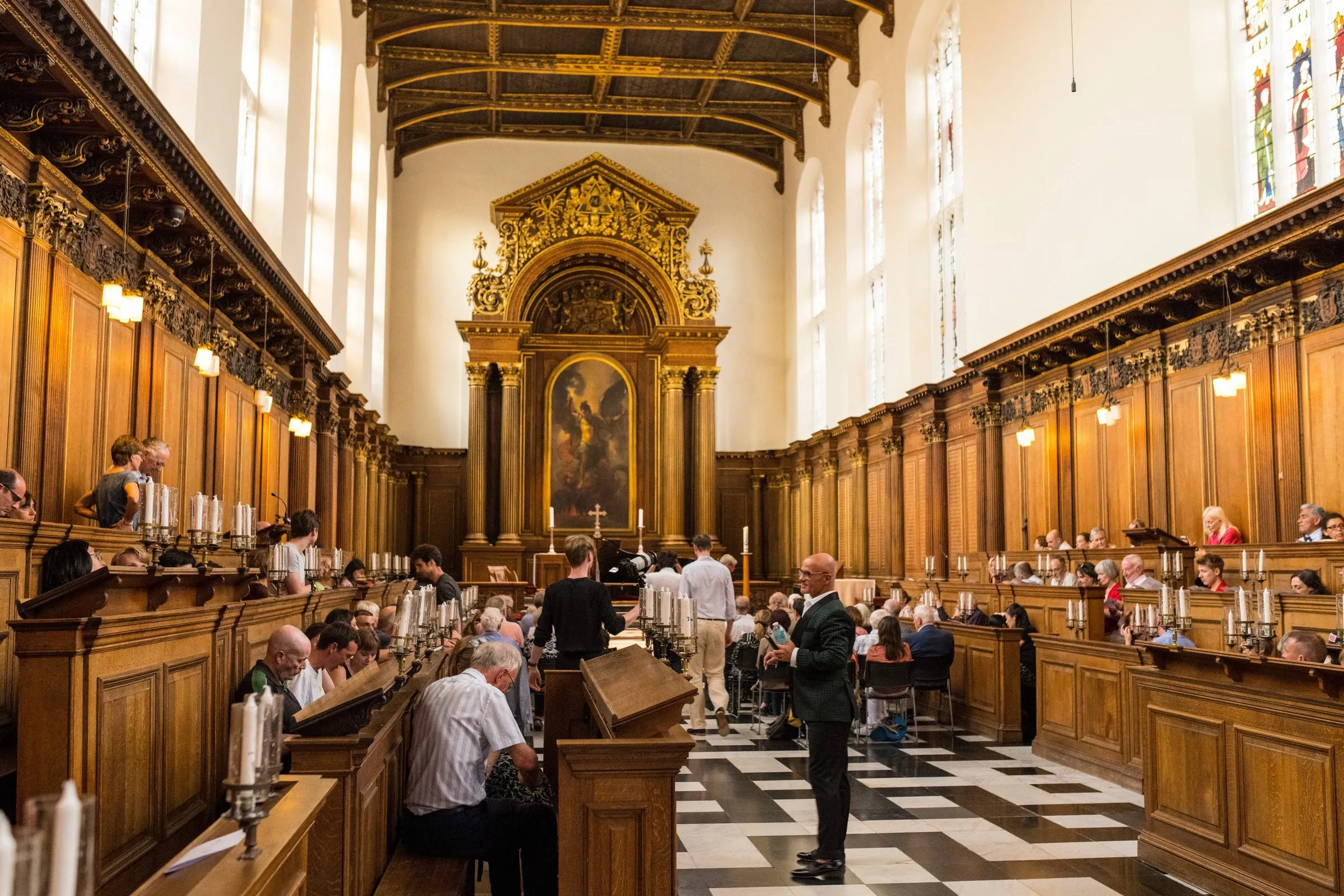 The audience in Trinity College Chapel, with performers beneath the altarpiece