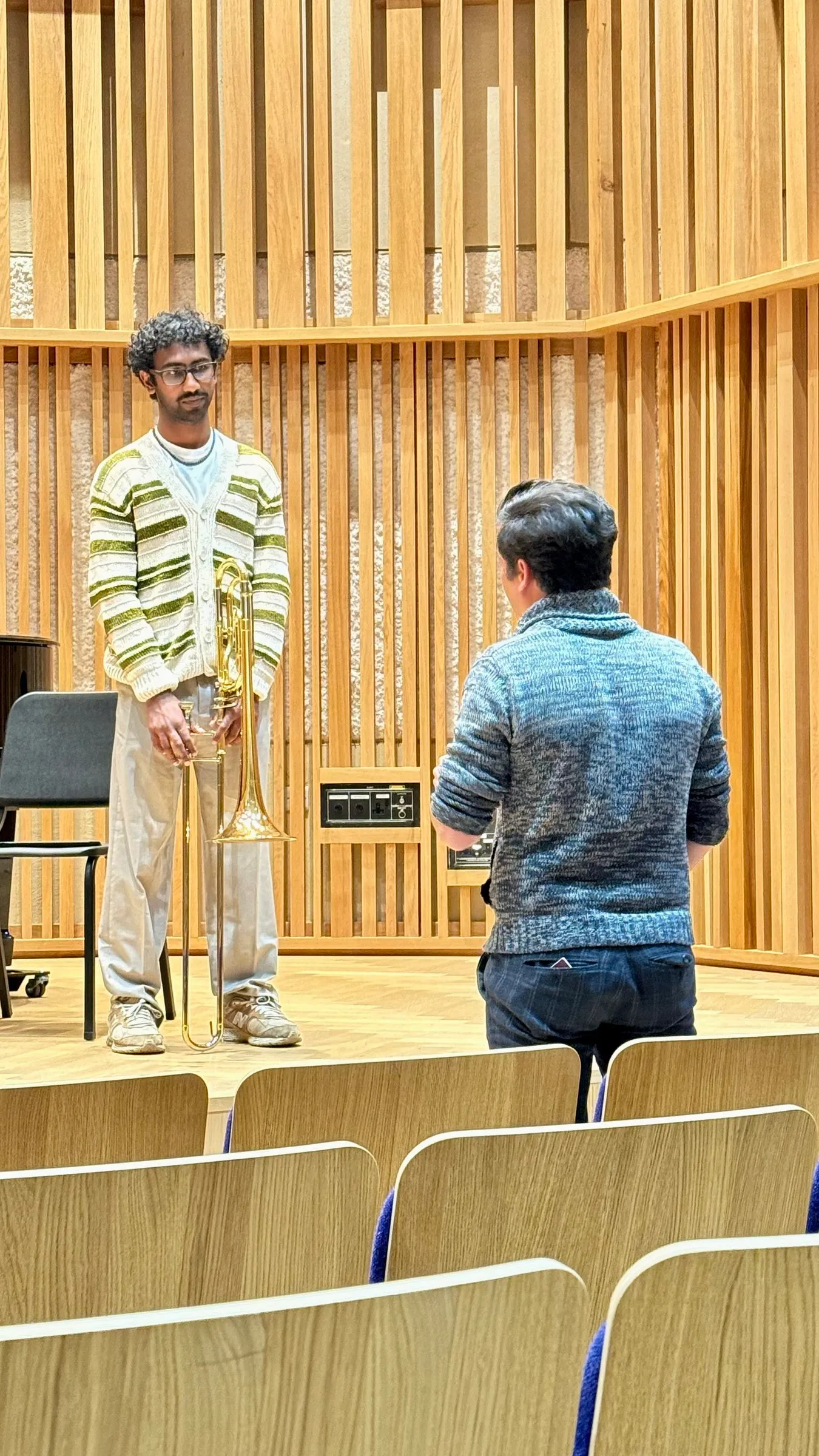 Two musicians on stage, seen from the empty seats